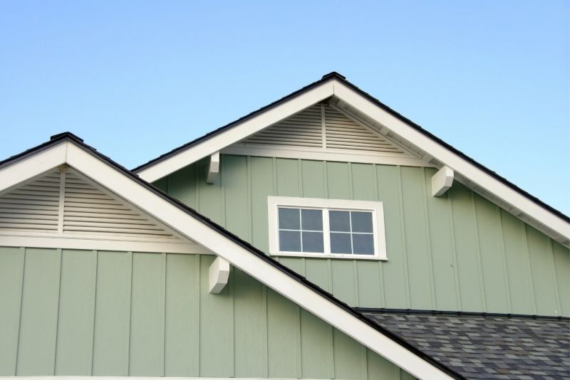 Close-up of a home's gabled roofline with white eaves trim and gable vents