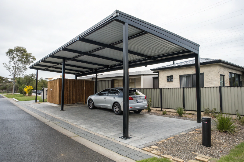 Industrial style single carport with corrugated metal roof and black steel posts