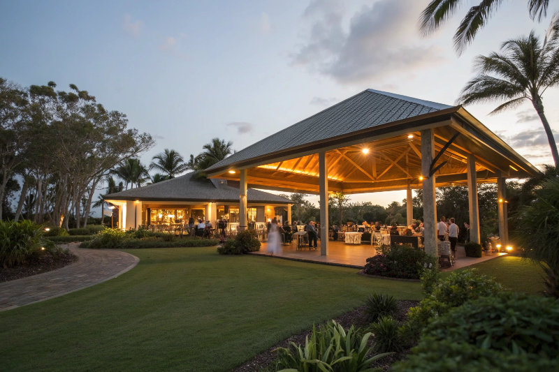 Large outdoor pavilion hosting an evening gathering with a crowd of guests